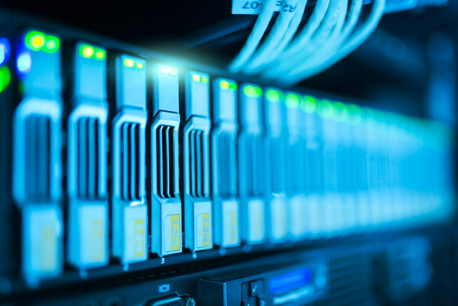 After — neatly dressed, colour-managed cabling across a row of rack-mounted servers with healthy green status LEDs.